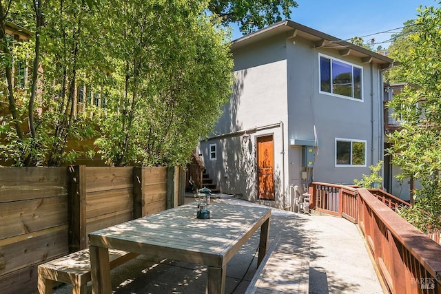 5 Oak Springs Dr, San Anselmo, CA 94960 - back of house featuring fence, outdoor dining space, stucco siding, and stairs
