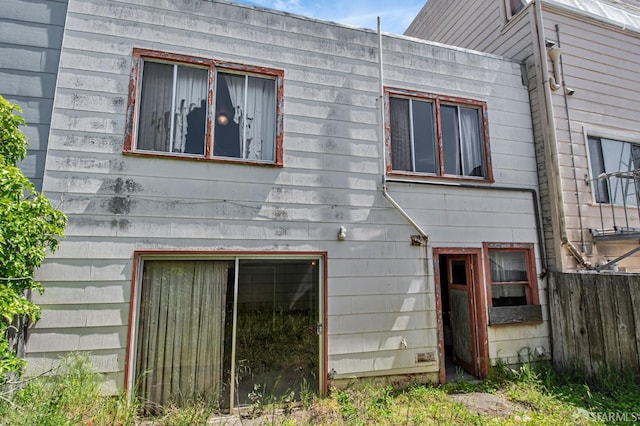 rear view of property featuring fence