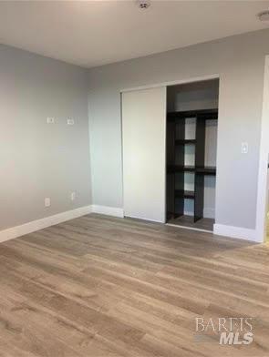 unfurnished room with baseboards and wood finished floors