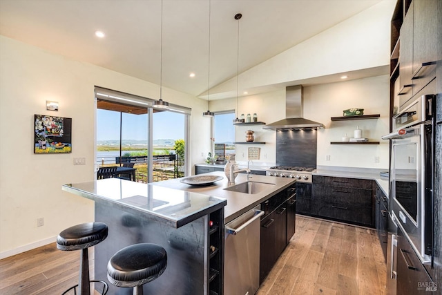kitchen featuring open shelves, a sink, wall chimney exhaust hood, and light wood-style floors