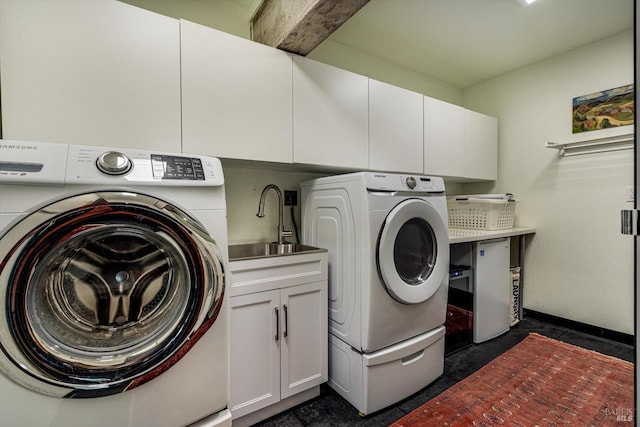clothes washing area with cabinet space, separate washer and dryer, and a sink