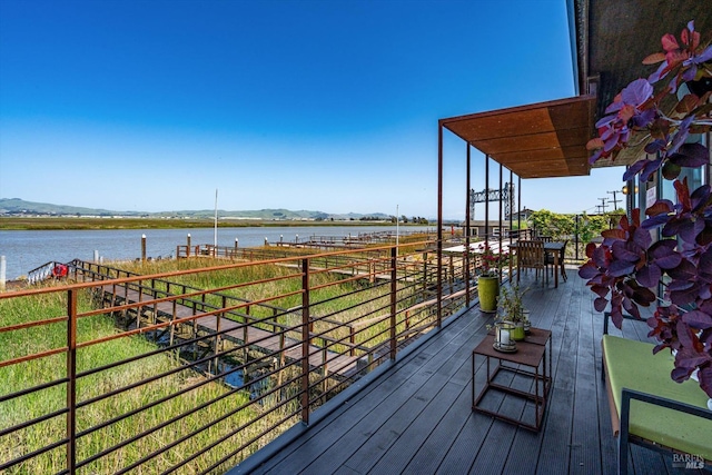 wooden deck with a water and mountain view