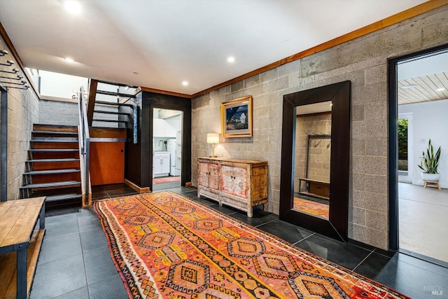 entrance foyer featuring recessed lighting, dark tile patterned floors, and stairs
