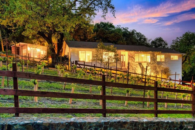 back of house at dusk with fence private yard