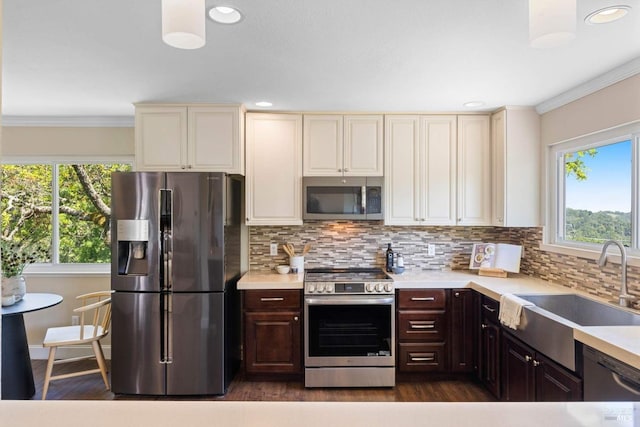 kitchen with light countertops, appliances with stainless steel finishes, plenty of natural light, and a sink