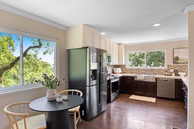 kitchen featuring a sink, appliances with stainless steel finishes, backsplash, and light countertops