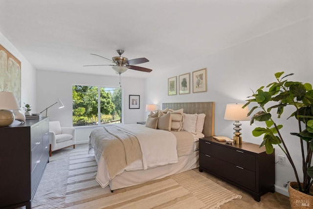 bedroom with baseboards, ceiling fan, and light carpet