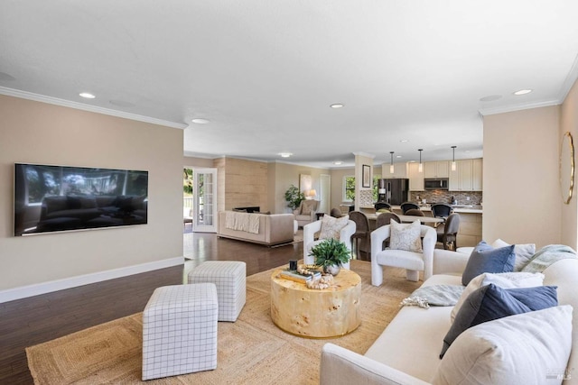 living area featuring baseboards, ornamental molding, and recessed lighting