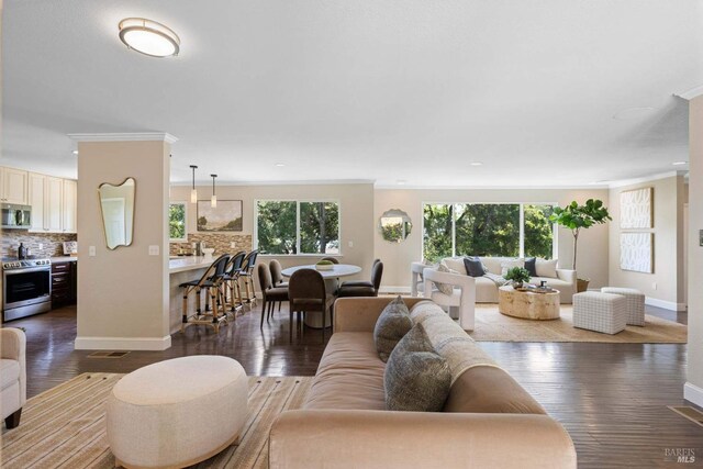 living area featuring a healthy amount of sunlight, baseboards, recessed lighting, and dark wood-style flooring