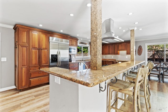 28 Washington St, Novato, CA 94947 - kitchen with built in appliances, island exhaust hood, ornamental molding, recessed lighting, and plenty of natural light