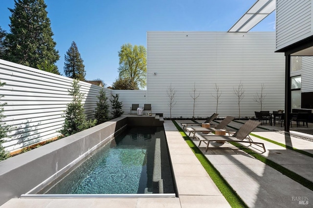 pool with a fenced backyard and a patio area