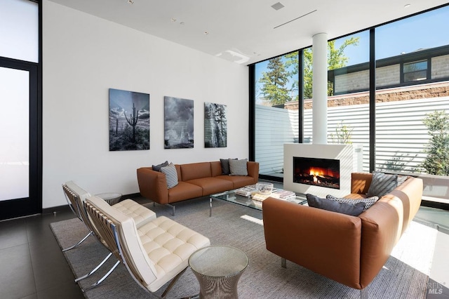 living room with a warm lit fireplace and floor to ceiling windows