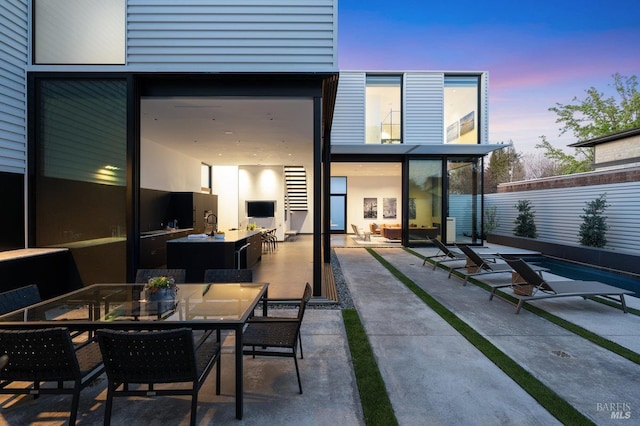 rear view of property featuring outdoor dining area and a patio area