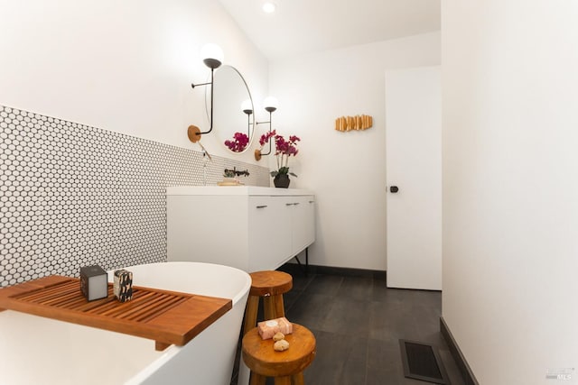 full bath featuring visible vents, wood finished floors, baseboards, a soaking tub, and recessed lighting
