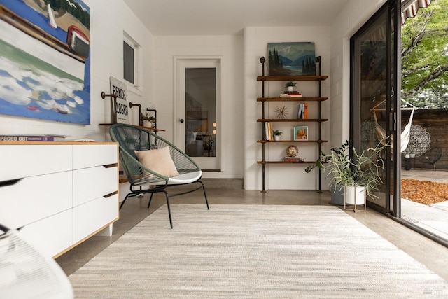 sitting room featuring plenty of natural light and concrete flooring