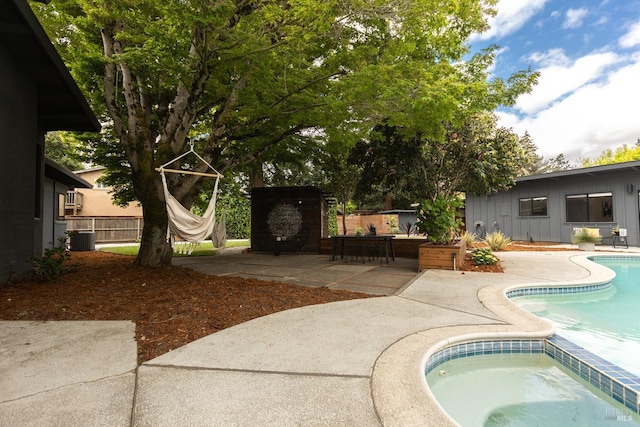 pool featuring fence, central air condition unit, and a patio area