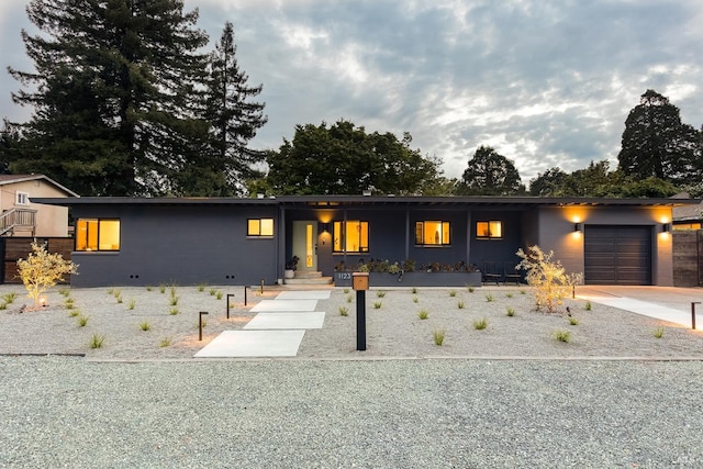 ranch-style home featuring an attached garage, concrete driveway, and a porch