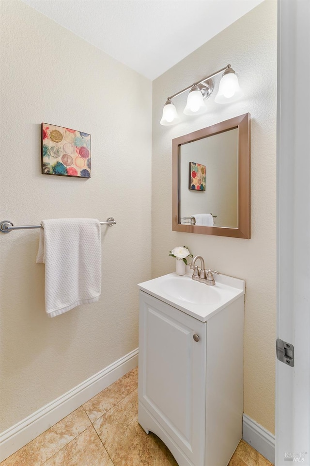 bathroom featuring vanity, tile patterned flooring, and baseboards