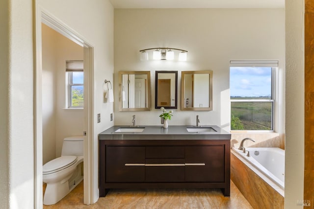 full bath with a sink, double vanity, toilet, and a bath