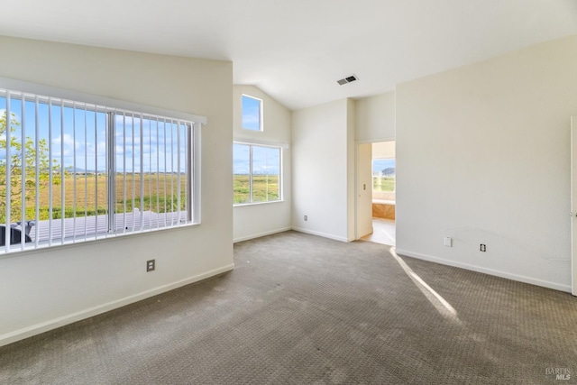 spare room featuring visible vents, baseboards, carpet, and lofted ceiling