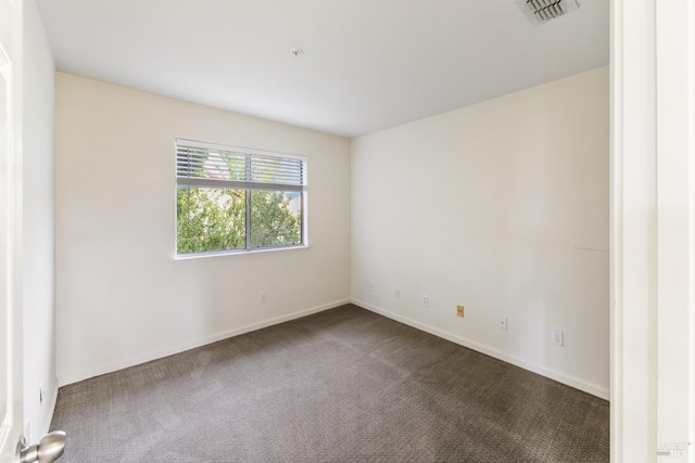carpeted spare room featuring visible vents and baseboards