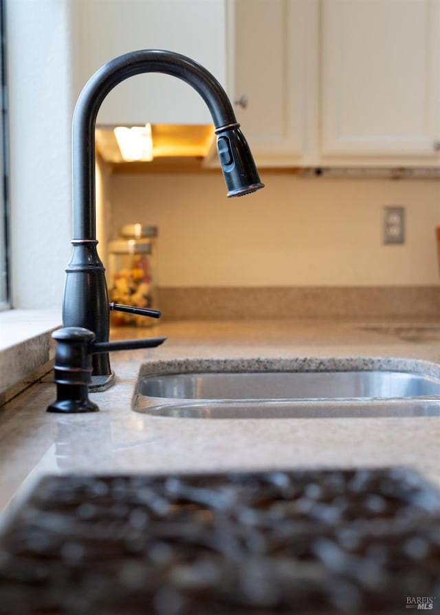 details with a sink and white cabinetry