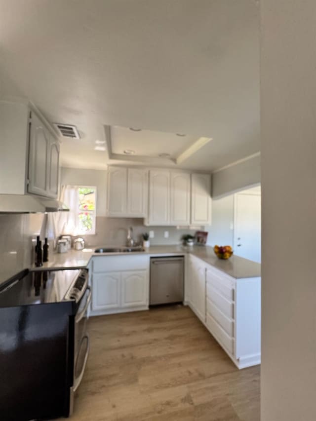 4647 Barbee Way, Sacramento, CA 95823 - kitchen featuring appliances with stainless steel finishes, a raised ceiling, light wood-style flooring, and white cabinetry