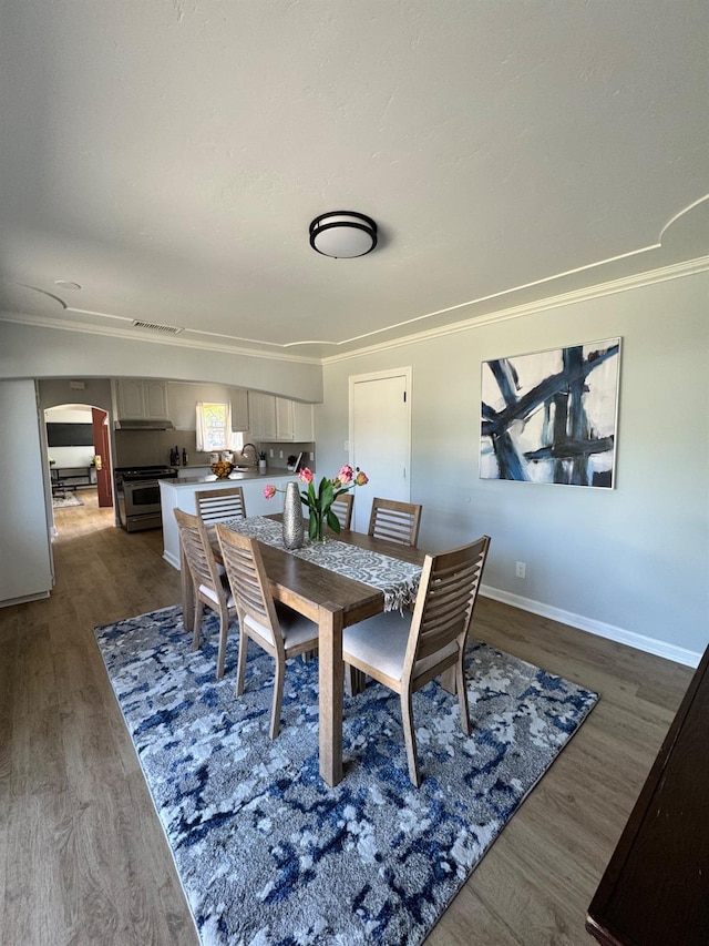 4647 Barbee Way, Sacramento, CA 95823 - dining space featuring ornamental molding, arched walkways, and dark wood finished floors