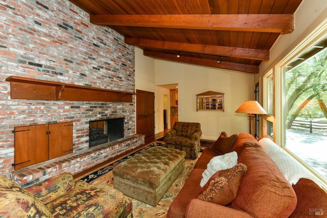 living room with lofted ceiling with beams, wood ceiling, baseboards, and a fireplace