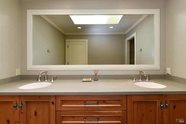 bathroom featuring double vanity, a sink, crown molding, and a skylight