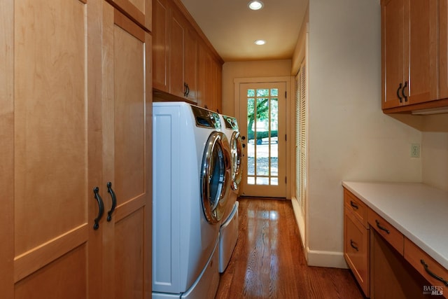 clothes washing area with independent washer and dryer, cabinet space, baseboards, recessed lighting, and light wood-style flooring