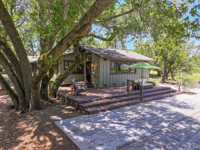exterior space with a wooden deck and a shingled roof