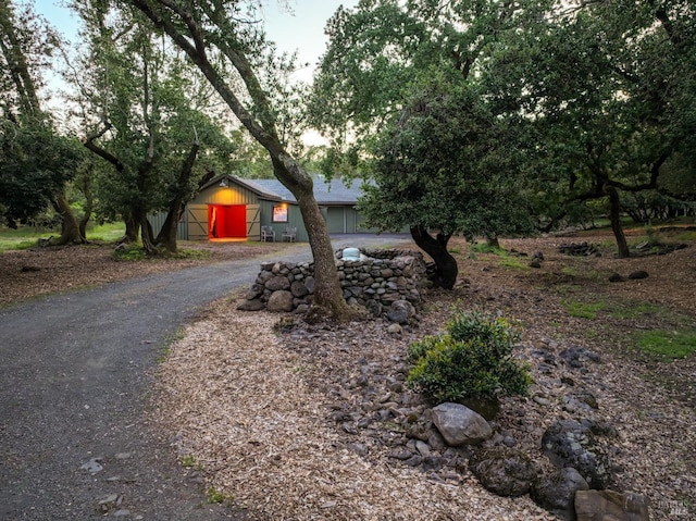 obstructed view of property with aphalt driveway
