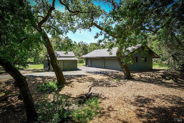 view of home's exterior with an outdoor structure and a detached garage