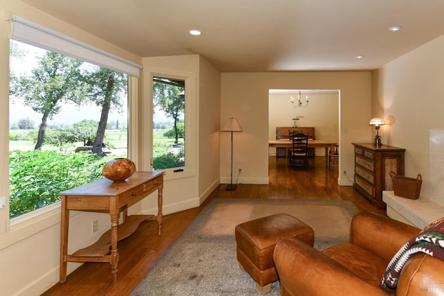 living room featuring recessed lighting, baseboards, wood finished floors, and a chandelier