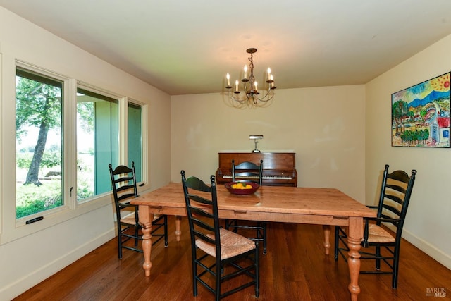 dining space featuring baseboards, dark wood finished floors, and an inviting chandelier