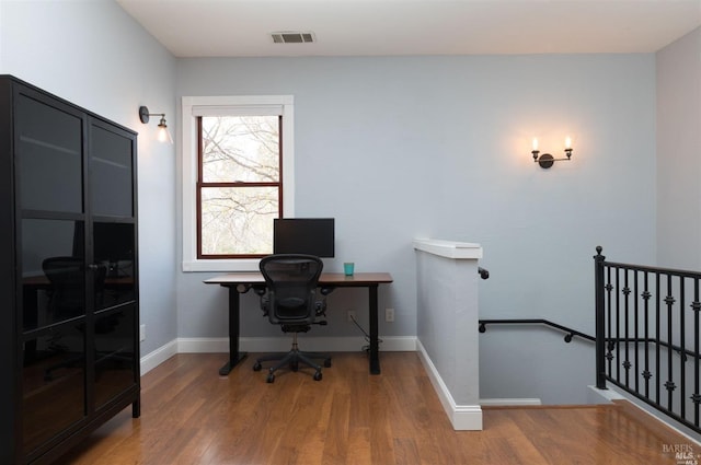 office featuring baseboards, visible vents, and wood finished floors