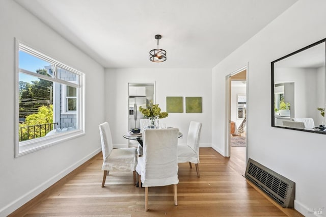 dining area featuring visible vents, light wood finished floors, and baseboards
