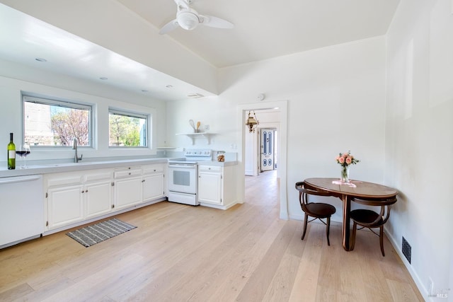 kitchen featuring white cabinets, a sink, light wood-style floors, white appliances, and light countertops