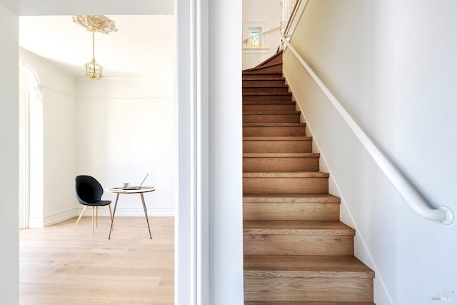 staircase with baseboards and wood finished floors
