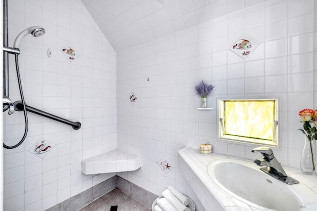 bathroom with tile patterned flooring, lofted ceiling, and tile walls