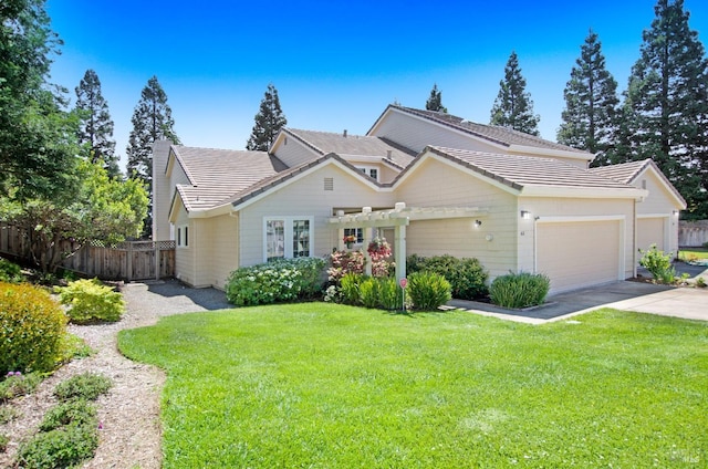 view of front of house featuring an attached garage, fence, driveway, and a front yard