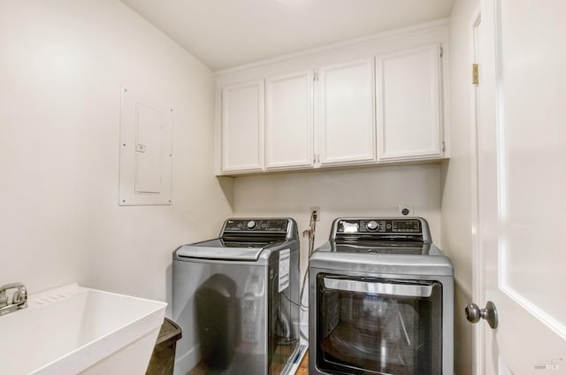 clothes washing area featuring washing machine and clothes dryer, a sink, electric panel, and cabinet space