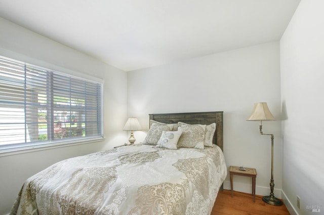 bedroom featuring baseboards and wood finished floors