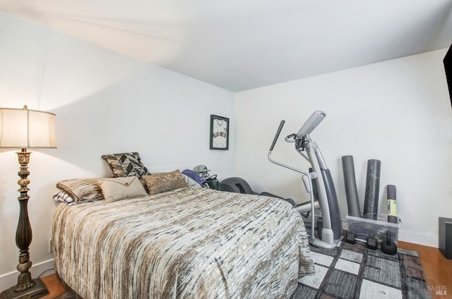 bedroom featuring baseboards and wood finished floors