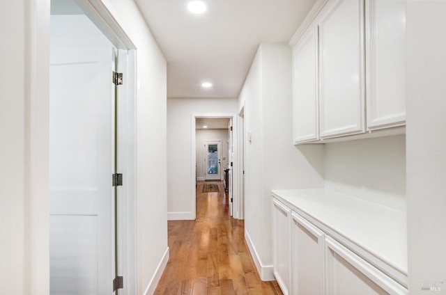hall featuring recessed lighting, light wood-style floors, and baseboards