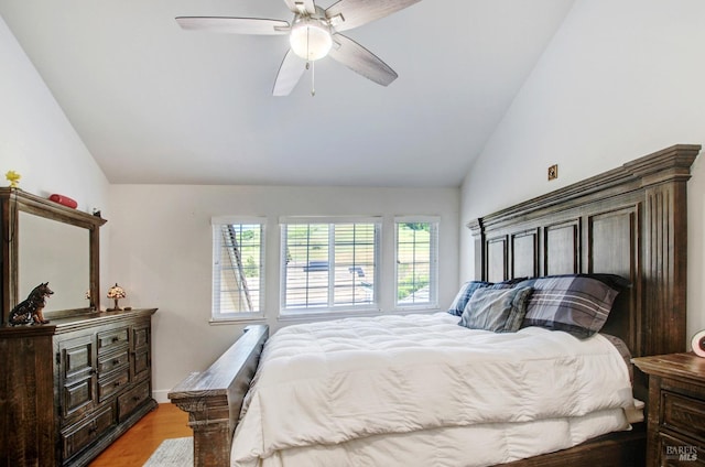 bedroom with ceiling fan, light wood-style flooring, and lofted ceiling