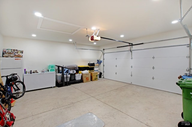 garage with recessed lighting, a garage door opener, and freestanding refrigerator
