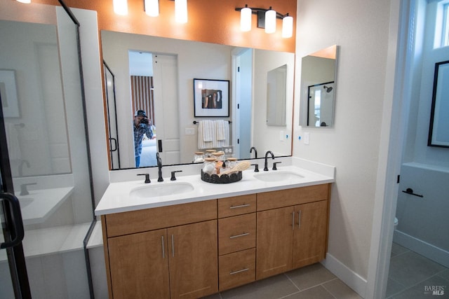 bathroom with a sink, baseboards, tile patterned flooring, and double vanity