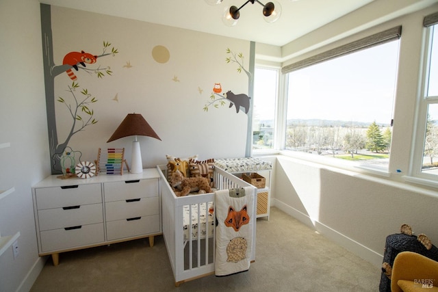 bedroom with light colored carpet, baseboards, and a notable chandelier